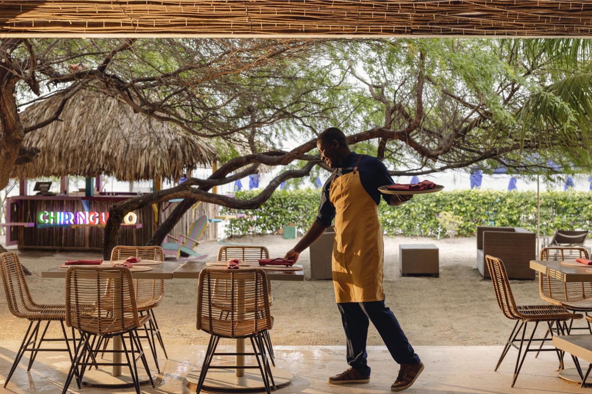 Santa Marta Marriott Resort Playa Dormida Kültér fotó A waiter clearing a table
